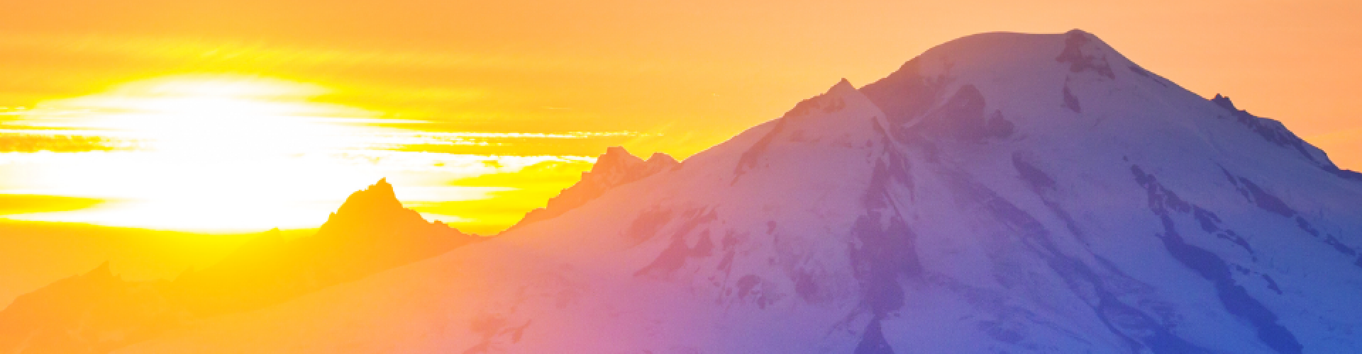 orange sunset behind purple mountains