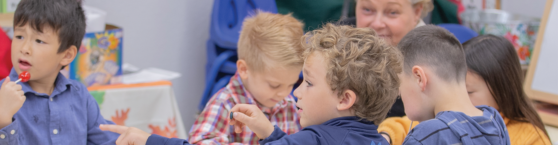 group of young children and adult teacher sit in Sunday catechism class