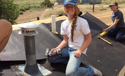 Young woman from High School Mission Team works on roof