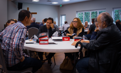 Genuine Community; people talking around a table; friends