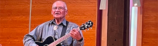 Pastor JR of the House of Joy church on the Navajo reservation stands in the front of the sanctuary while playing a guitar and singing