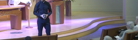 Pastor Matt stands in front of altar to deliver sermon